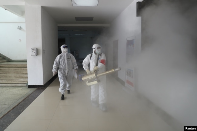 2020年2月22日身穿防护服的志愿者在武汉住宅区消毒。