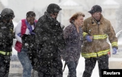 FILE - Two women are evacuated from a Colorado Springs, Colorado building where a shooter was suspected to be holed up November 27, 2015.