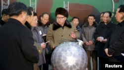 지난해 3월 김정은 북한 국방위원회 제1위원장이 핵무기 연구 부문 과학자, 기술자들을 만나 핵무기 병기화 사업을 지도하는 모습을 조선중앙통신이 보도했다. 사진 아래쪽에 핵탄두 기폭장치 추정 물체가 보인다.
