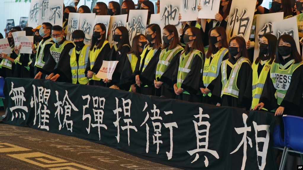 香港中文大学毕业生在2019年11月7日的毕业典礼上戴口罩手举标语横幅抗议。