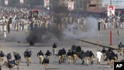 Police chase protesters during an anti-U.S. rally in Peshawar, Pakistan, September 21, 2012. 