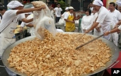 FILE - Thai chefs cook vegetarian food from a giant cooking bowl during the vegetarian festival celebration in Chiang Mai province, northern Thailand, Sept. 24, 2014.