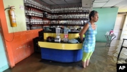 FILE - A woman stands in a flooded disco in Juanchito, Colombia, Dec. 7, 2011.