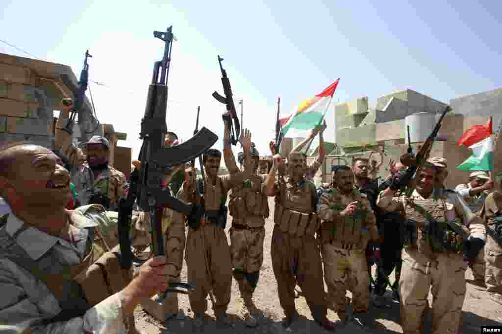 Kurdish peshmerga forces celebrate taking control of Sulaiman Bek from the Islamic State militants, in the northwest of Tikrit city, Sept. 1, 2014.