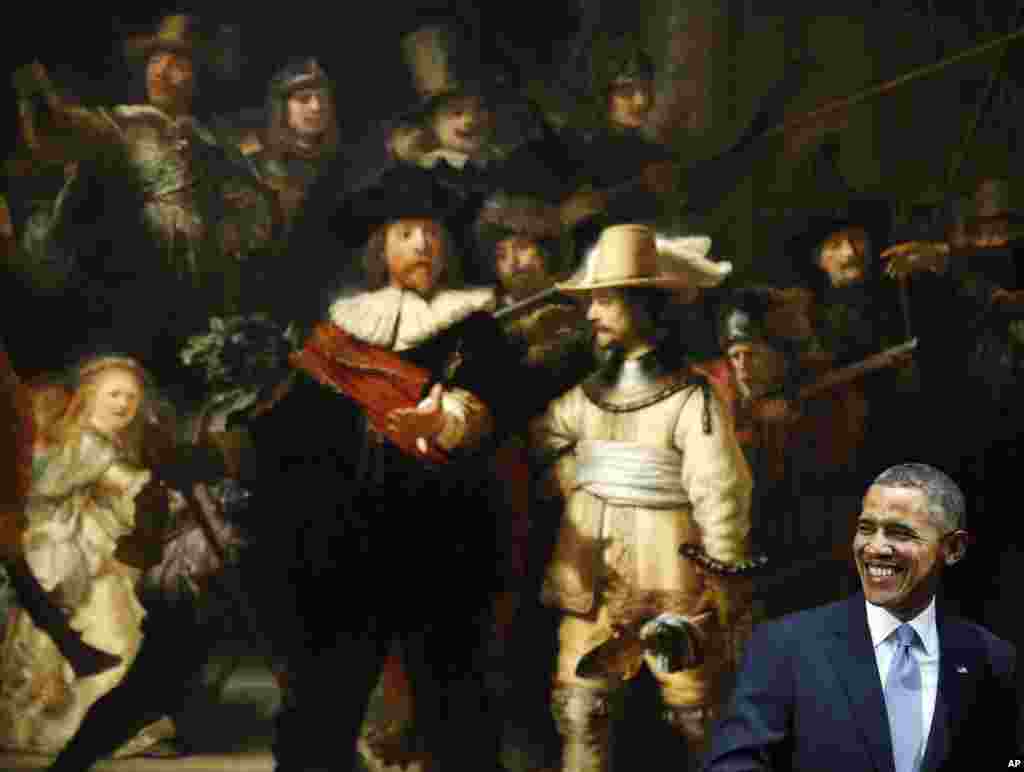 U.S. President Barack Obama smiles in front of Dutch master Rembrandt's The Night Watch painting during a visit to the Rijksmuseum in Amsterdam, Netherlands.