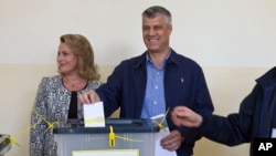 Kosovo Prime Minister Hashim Thaci, joined by his wife Lumnije casts his vote at a polling station in Pristina, Nov 3, 2013.