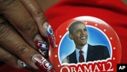 Seorang anggota delegasi Partai Demokrat di Charlotte menunjukkan brosnya yang bergambarkan Presiden Obama.