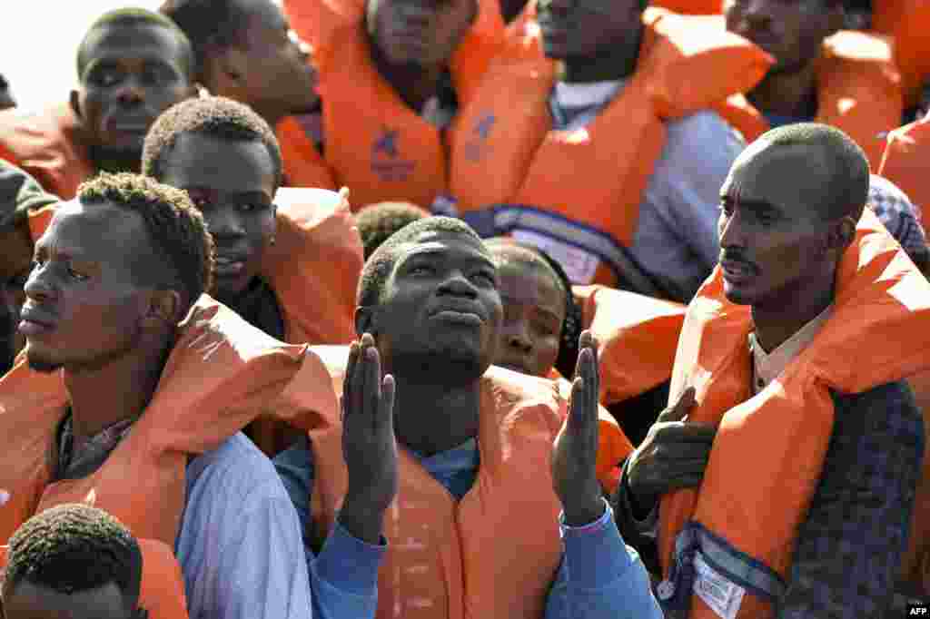 Migrants and refugees seated on a rubber boat wait to be rescued by the Topaz Responder, a rescue ship run by Maltese NGO Moas and the Italian Red Cross off the Libyan coast.