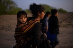 Mayra, a 17-year-old asylum-seeking mother from Guatemala, carries her 13-month-old son Marvin after they crossed the Rio Grande river into the United States from Mexico on a raft in Penitas, Texas, U.S., March 17, 2021. (REUTERS/Adrees Latif)
