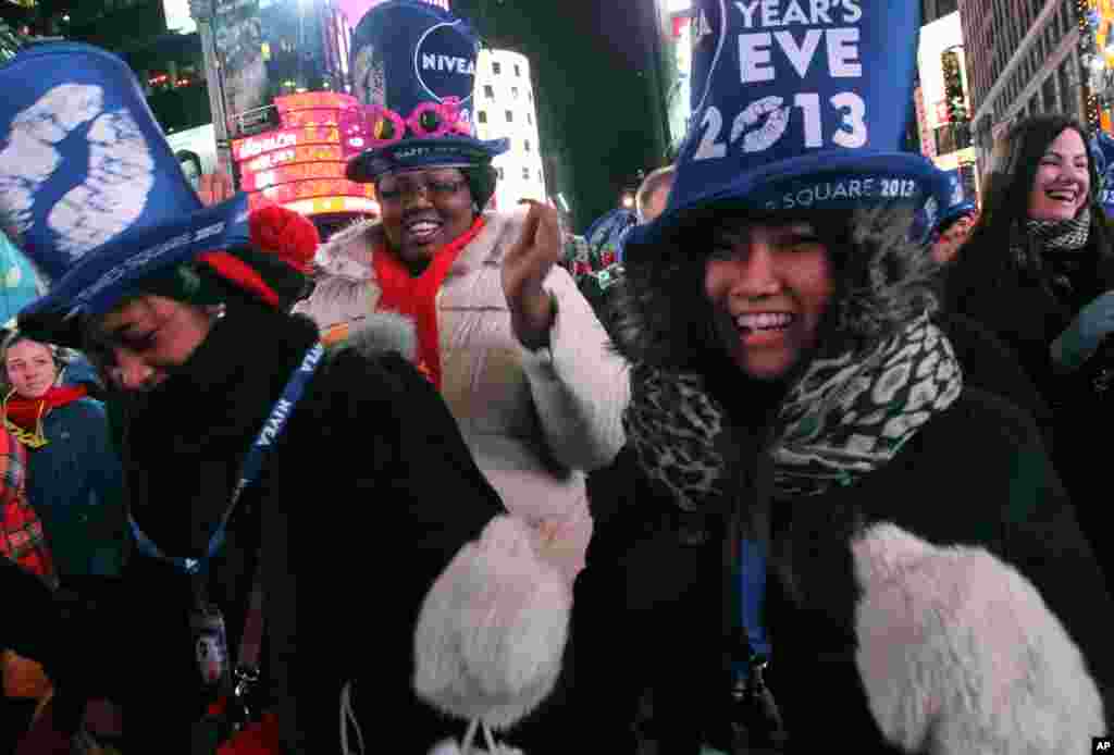 Tatiana Rakotovazaha, from Madagascar, foreground left, Aurielle Williams, from Kansas, center, and Yayoi Okayama, from Japan, foreground right, dance as they take part in the New Year's Eve festivities in New York's Times Square on Dec. 31, 2012.