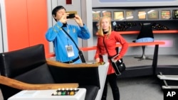 Keith Schubert (L) of Peru, New York, dressed as Star Trek's Mr. Spock, and his daughter Tiffany, dressed as a crew member, take photographs during a tour of a replica starship Enterprise, in Ticonderoga, New York, Aug. 13, 2016.