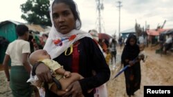 A Rohingya refugee carries 