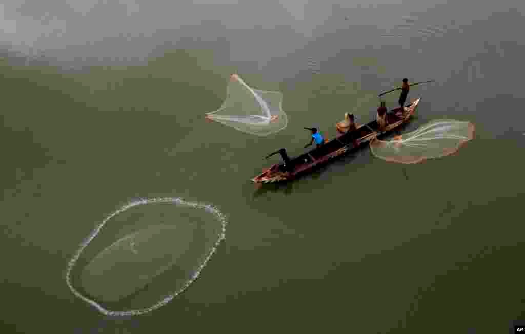 Nelayan melemparkan jaring ke Sungai Mahanadi di pinggiran Cuttack, India.
