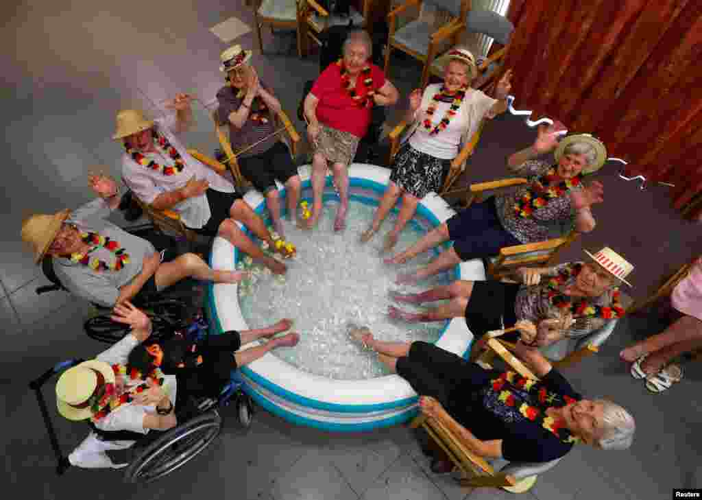 Residents at the Ter Biest house for elderly persons refresh their feet in a pool on a hot summer day, in Grimbergen, Belgium.