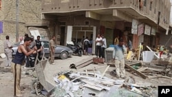 People gather at the scene of a car bomb attack in the Amil neighborhood of Baghdad, Iraq, April 19, 2012. 