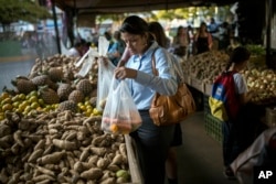 Carmen Victoria Gimenez, 43, shops at a farmers market in the middle-class district of Los Dos Caminos, in Caracas, Venezuela, Feb. 14, 2019.