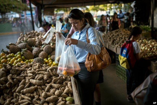 Carmen Victoria Gimenez, 43, shops at a farmers market in the middle-class district of Los Dos Caminos, in Caracas, Venezuela, Feb. 14, 2019.
