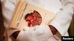 FILE - Delores Edwards holds copies of a program during a memorial service for American author and poet Maya Angelou at Mount Zion Baptist Church in Winston-Salem, North Carolina, May 29, 2014. 