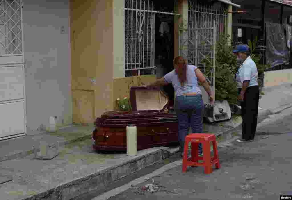 Una mujer mira un ataúd con el cadáver de su madre quien murió por coronavirus, en Guayaquil, Ecuador, el 30 de marzo de 2020.