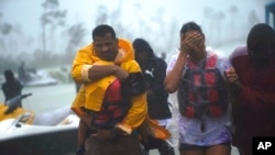 Une famille escortée dans une zone sûre après avoir été secourue aux Bahamas, le mardi 3 septembre 2019. (AP Photo / Ramon Espinosa)