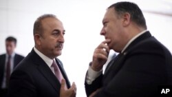 Turkey's Foreign Minister Mevlut Cavusoglu, left, talks with U.S. Secretary of State Mike Pompeo at the Esenboga Airport in Ankara, Turkey, Oct. 17, 2018. 