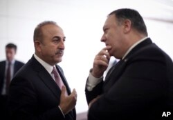 FILE - Turkey's Foreign Minister Mevlut Cavusoglu, left, talks with U.S. Secretary of State Mike Pompeo at the Esenboga Airport in Ankara, Turkey, Oct. 17, 2018.