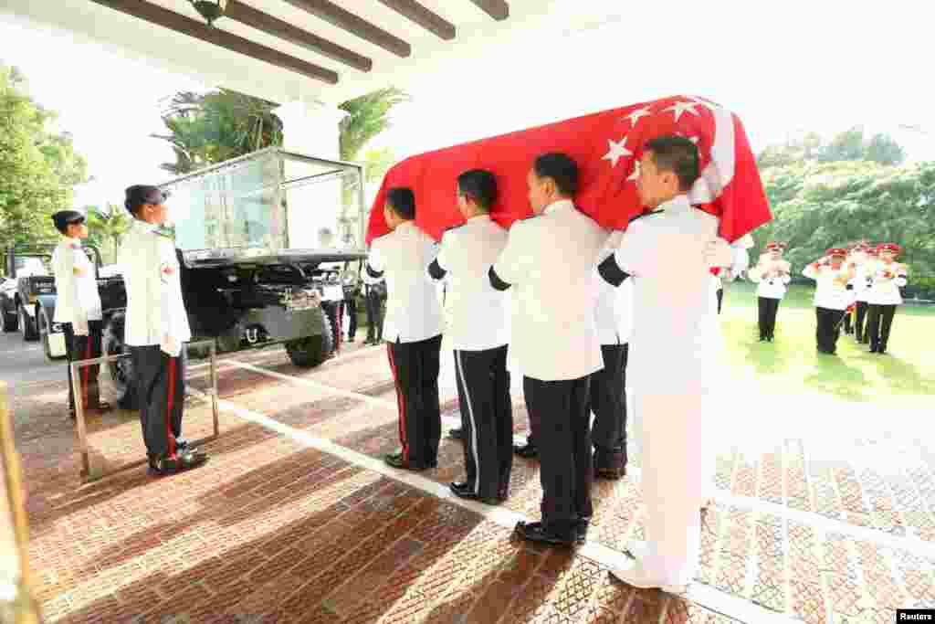 Pasukan Kehormatan membawa peti jenazah perdana menteri pertama Singapura, Lee Kuan Yew, ke atas kereta (25/3).