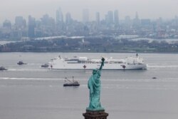 USNS Comfort melewati Patung Liberty saat memasuki Pelabuhan New York di tengah pandemi COVID-19 di New York City, AS, 30 Maret 2020. (REUTERS/Mike Segar/File)