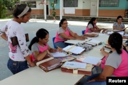 Teachers organize students' files on the first day of school, in Caucagua, Venezuela, Sept. 17, 2018.