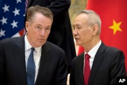 FILE - Chinese Vice Premier Liu He (R) talks with U.S. Trade Representative Robert Lighthizer, while they line up for a group photo at the Diaoyutai State Guesthouse in Beijing,Feb. 15, 2019.