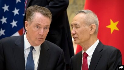 FILE - Chinese Vice Premier Liu He (R) talks with U.S. Trade Representative Robert Lighthizer, while they line up for a group photo at the Diaoyutai State Guesthouse in Beijing, Feb. 15, 2019. 