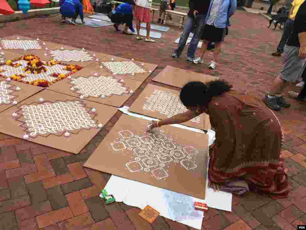 Seorang seniman menggambar di Kolam di pintu masuk Enid A. Haupt Garden. (S. Ali/VOA)