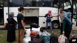 FILE - Syrian refugees prepare to board a bus for Istanbul, abandoning plans to cross to Europe near Turkey’s western border with Greece and Bulgaria, in Edirne, Turkey, Wednesday, Sept. 23, 2015.