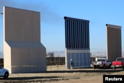 FILE - Three of U.S. President Donald Trump's eight border wall prototypes are shown near completion along U.S.- Mexico border in San Diego, California, Oct. 23, 2017.