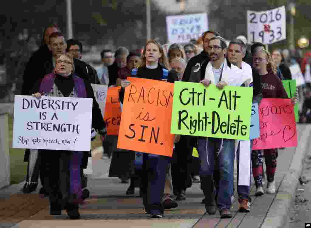 Demonstrators hold signs as they chant outside the venue where Richard Spencer, who leads a movement that mixes racism, white nationalism and populism, is scheduled to speak at Texas A&M University in College Station, Texas, Dec. 6, 2016.
