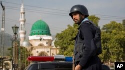 FILE - A Pakistani police officer stands guard outside the Barri Imam shrine, as security is beefed up in the capital following a suicide attack at a Sufi shrine in interior Sindh, Islamabad, Pakistan, Feb. 17, 2017. Pakistan hosted a meeting Wednesday with Russia, China and Iran to discuss counterterrorism cooperation.