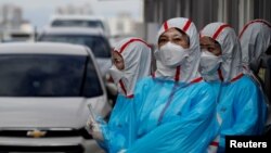 Petugas medis Korea Selatan memeriksa suhu tubuh pengendara mobil secara "drive thru" untuk mencegah perebakan virus corona yang masih terus meluas di Yeungnam University Medical Center, Daegu (foto: dok). 
