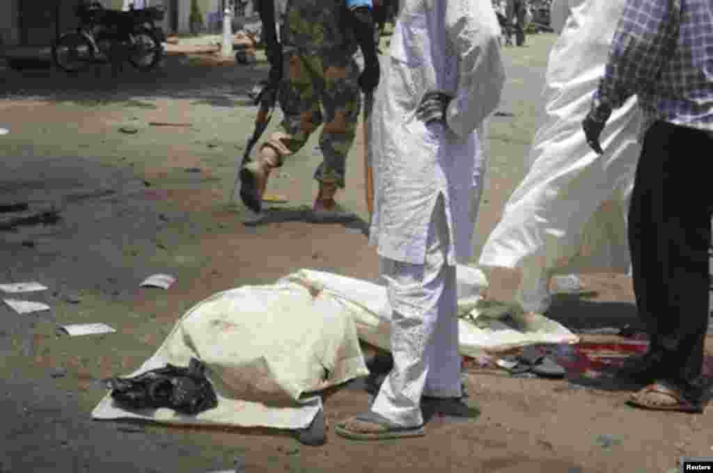 The body of a victim lies covered on the ground after a bomb blast in front of the office compound of Nigerian newspaper This Day in the northern city of Kaduna April 26, 2012.