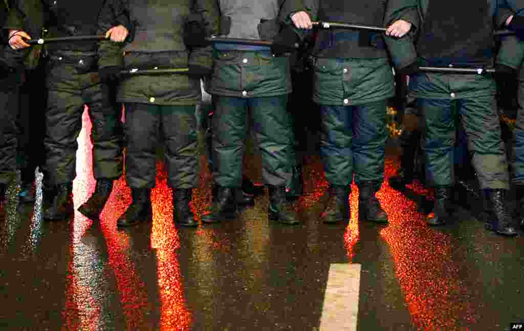 Đèn đỏ của xe cảnh sát phản chiếu trên đường có nước mưa, tại một nút chặn của cảnh sát sau một cuộc tụ tập tại trung tâm Moscow. (AP/Alexander Zemlianichenko)