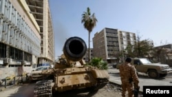 Anggota pasukan pro-pemerintah Libya berdiri dekat tank di Benghazi, Libya (21/1). (Reuters/Esam Omran)