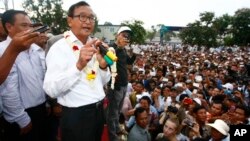 Head of opposition Cambodia National Rescue Party Sam Rainsy, second from left, gives a speech during a rally of their supporters after the July 28 polls, in Phnom Penh, file photo. 