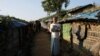 FILE - Noor Islam, from Taung Bazar village in Buthidaung township, poses for a picture with a satellite image of his burnt village in Myanmar, at the Kutupalong camp in Cox's Bazar, Bangladesh, October 15, 2018.