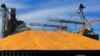 FILE - Central Illinois farmers pile harvested corn on the ground outside a full grain elevator in Virginia, Ill., Sept. 23, 2015. 