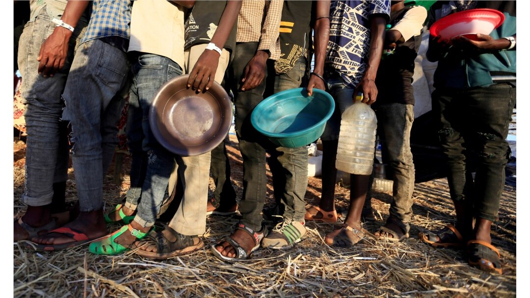Pengungsi Ethiopia yang melarikan diri dari wilayah Tigray, antre untuk menerima bantuan makanan di dalam kamp Um-Rakoba, negara bagian Al-Qadarif, di perbatasan Sudan, 11 Desember 2020. (Foto: REUTERS / Mohamed Nureldin Abdallah)
