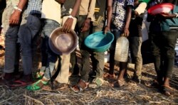 Pengungsi Ethiopia yang melarikan diri dari wilayah Tigray, antre untuk menerima bantuan makanan di dalam kamp Um-Rakoba, negara bagian Al-Qadarif, di perbatasan Sudan, 11 Desember 2020. (Foto: REUTERS / Mohamed Nureldin Abdallah)