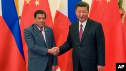 Philippine President Rodrigo Duterte, left, and Chinese President Xi Jinping pose for photographers prior to their bilateral meeting held on the sidelines of the Belt and Road Forum for International Cooperation at the Great Hall of the People in Beijing,