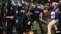 FILE - A police officer tries to grab a demonstrator during protests in downtown Charlotte, N.C., Sept. 21, 2016.