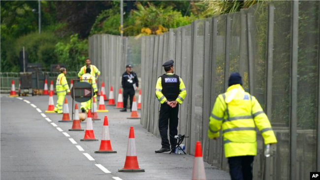 Oficerët e policisë bëjnë roje pranë gardhit që qarkon Kështjellën Tregenna, Cornwall, Angli (9 qershor 2021)