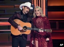 Hosts Brad Paisley, left, and Carrie Underwood appear during the opening of the 51st annual CMA Awards at the Bridgestone Arena, Nov. 8, 2017, in Nashville, Tennessee.