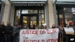 Protesters block an entrance to Banana Republic store on Friday, Nov. 27, 2015, in Chicago as community activists and labor leaders hold a demonstration responding to the release of a video showing an officer fatally shooting Laquan McDonald. (AP Photo/Nam Y. Huh)